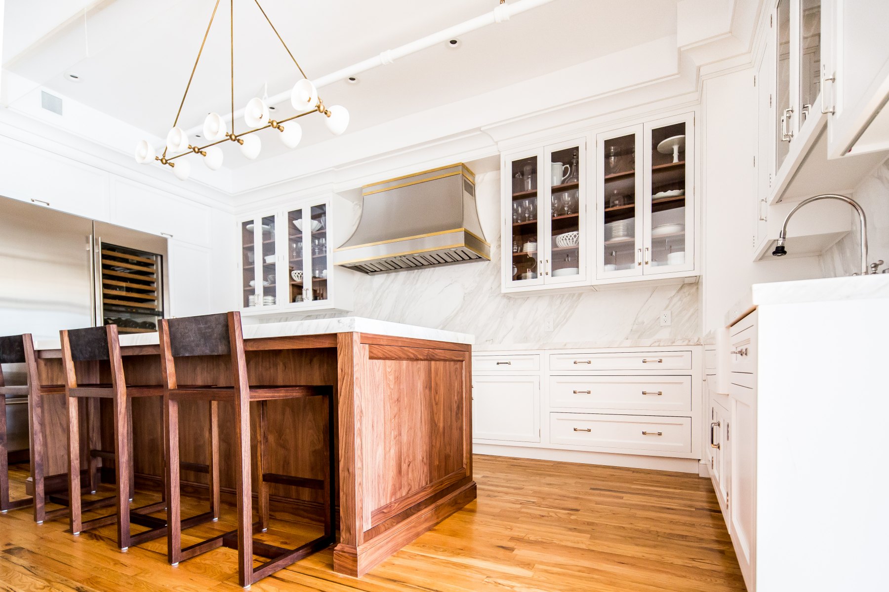 Kitchen island and brass-trimmed hood